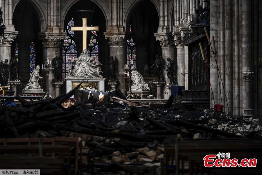 Rubble and the cross inside the Notre Dame de Paris Cathedral, Wednesday May 15, 2019 in Paris. French Culture Minister Franck Riester says that one month after a fire engulfed Notre Dame Cathedral, the edifice is still being made safe enough for restoration to begin. (Photo/Agencies)