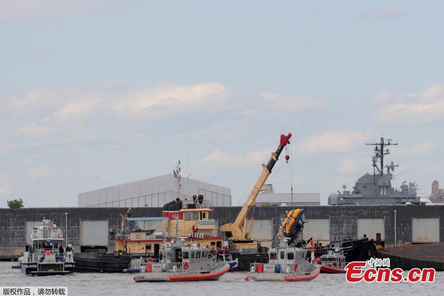 A helicopter is loaded, by crane, onto a barge after it crashed into the Hudson River on May 15, 2019 in New York.  A helicopter crashed into the Hudson River on May 15 afternoon shortly after taking off from a Manhattan heliport, authorities said. The pilot, identified as Eric Morales, was rescued by a passing NY Waterway ferry a short time later.(Photo/Agencies)