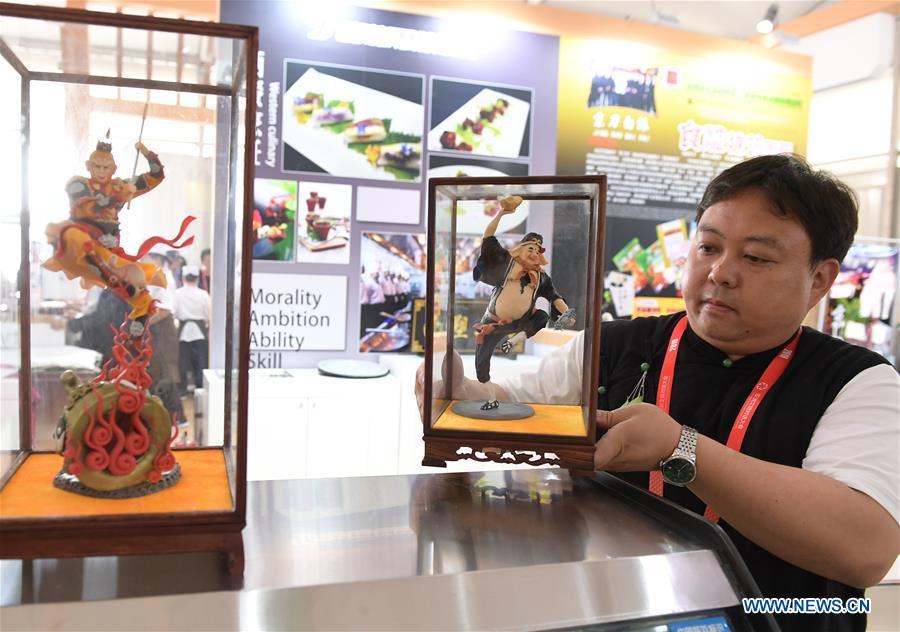 An artisan of dough sculpture displays a dough sculpture during the Asian Cuisine Festival at the Olympic Park in Beijing, capital of China, May 16, 2019. The week-long Asian Cuisine Festival, as part of the Conference on Dialogue of Asian Civilizations (CDAC), was held in four cities of Beijing, Hangzhou, Chengdu and Guangzhou. (Xinhua/Li He)
