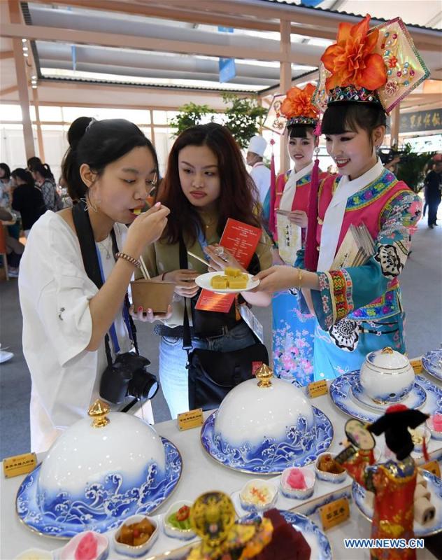 Visitors taste traditional Beijing snacks during the Asian Cuisine Festival at the Olympic Park in Beijing, capital of China, May 16, 2019. The week-long Asian Cuisine Festival, as part of the Conference on Dialogue of Asian Civilizations (CDAC), was held in four cities of Beijing, Hangzhou, Chengdu and Guangzhou. (Xinhua/Wang Yuguo)