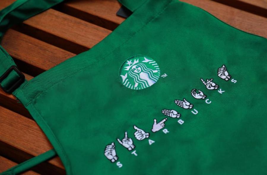 An apron at a Starbucks in Guangzhou\'s Yuexiu district with sign language capability uses finger spelling symbols above the letters of the company\'s name, May 19, 2019. (Photo provided to chinadaily.com.cn)