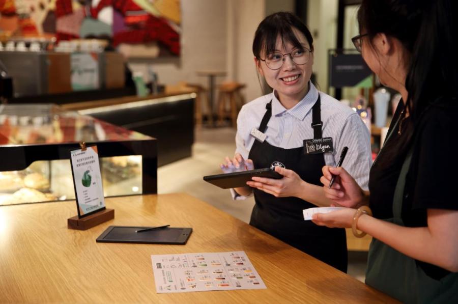 An employee able to communicate in sign language works at Starbucks China\'s first store with sign language capability in Guangzhou\'s Yuexiu district, May 19, 2019. (Photo provided to chinadaily.com.cn)
For customers new to sign language, there will be a dedicated area for customers to write down their orders on an electronic board and wireless vibrating pagers will notify customers when their orders are ready.

To create an inclusive environment and encourage customers to learn more about the deaf community, the store also will offer sign language lessons and coffee workshops in sign language, in partnership with the Guangdong Deaf People Association.

This is Starbucks\' third signing store worldwide, after Kuala Lumpur and Washington.