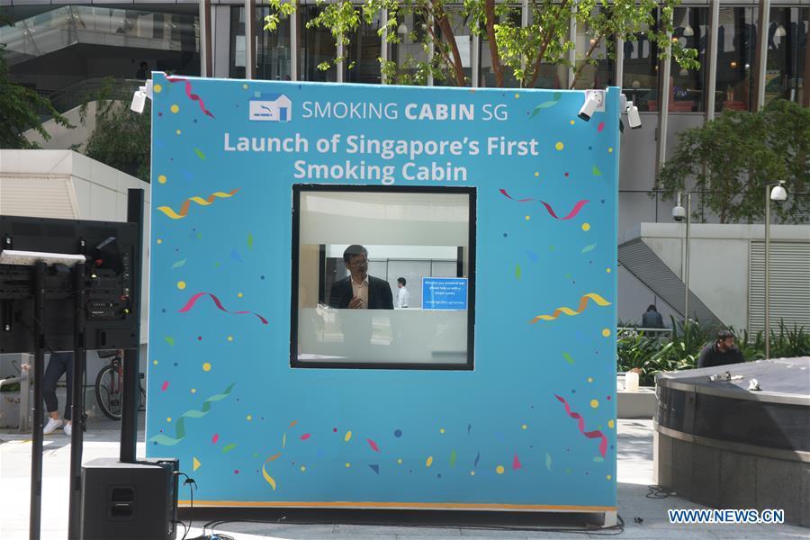 A man smokes inside a smoking cabin in Singapore on May 21, 2019. Singapore\'s first smoking cabin was launched on Tuesday. The air-conditioned cabin measures 4.8 square metres in size, that allows a maximum of 10 users at one time, and uses 3 filters to filter the air inside. (Xinhua/Then Chih Wey)