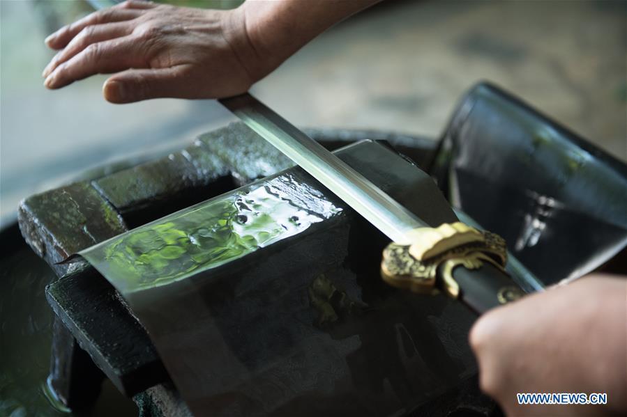 <?php echo strip_tags(addslashes(Wu Changyou, a co-worker of Zheng Guorong, burnishes a sword at Guyue Sword Studio in Longquan, east China's Zhejiang Province, May 21, 2019. For centuries, Longquan has been famed for its sword making industry. Zheng Guorong, 55, an intangible cultural heritage inheritor in Longquan Sword making, has been making sword for more than 30 years. Zheng regards sword as a symbol of spirit and devotes all to his career with awe. In his studio, the whole process of making a single sword takes two to three months, with steps including forming an idea, designing the sketch, preparing material and the final making and assembling. After setting up his studio, Zheng has trained more than 20 apprentices, who have all become sword smiths of great reputation. The old sword smith insists that Longquan sword, with a history of more than 2,500 years, deserves to be carried on in our time, both materially and spiritually. (Xinhua/Weng Xinyang))) ?>