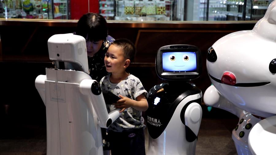 A child chats with an AI robot at the X Future Restaurant.  (Photo/People\'s Daily Online)