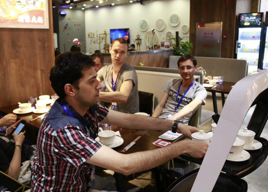 A customer takes food from a robot at the X Future Restaurant. (Photo/People\'s Daily Online)
