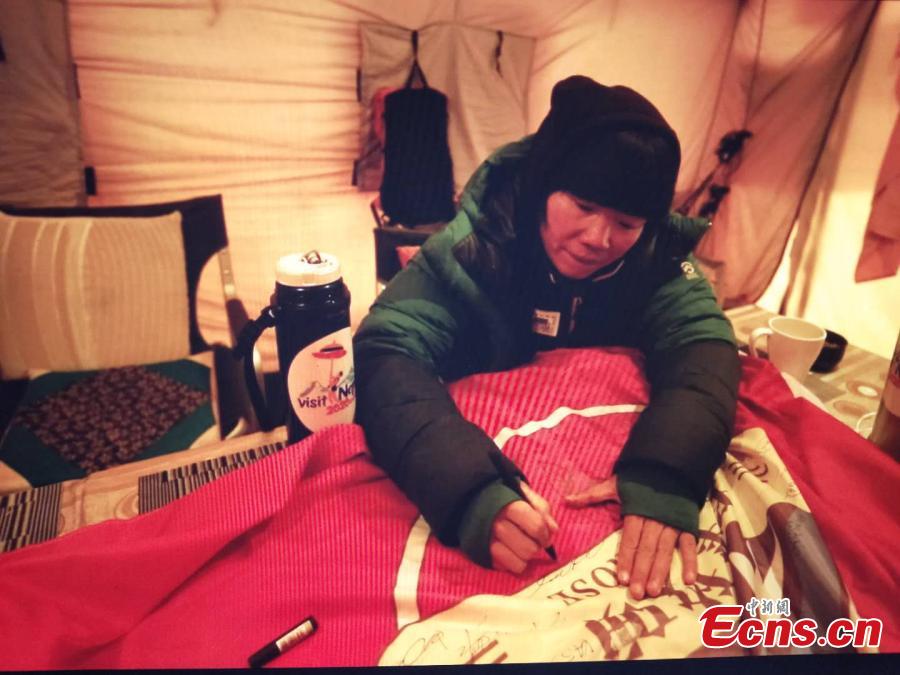 <?php echo strip_tags(addslashes(A female mountaineer signs a banner before climbing Mount Qomolangma, known as Mount Everest in the West, on May 22, 2019.(Photo/China News Service))) ?>