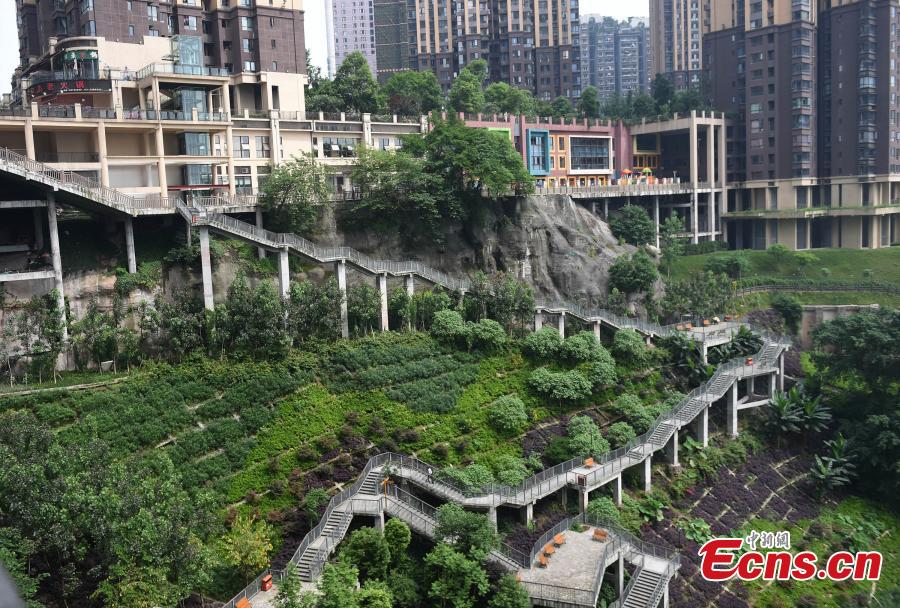 A view of a pathway built along a hilly slope leading to the entrance of a residential community in Yuzhong District, Southwest China’s Chongqing Municipality, May 22, 2019. The road is about one kilometre long, with a height of nearly 100 meters. Built on mountains, the city has been nicknamed a \