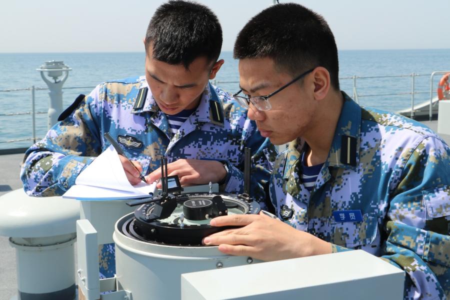 Two cadets are practicing using a nautical tool.  (Photo provided to chinadaily.com.cn)