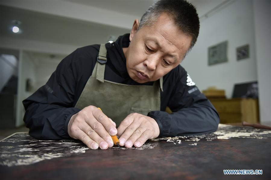 <?php echo strip_tags(addslashes(Chen Dongming works on a wood-block painting at his studio in Huanren County of Benxi, northeast China's Liaoning Province, May 27, 2019. Chen Dongming, a 52-year-old wood-block painter from Wafang Village of Huanren County in Benxi, learned the techniques from his grandfather since young. As an inheritor of Huanren wood-block painting, a provincial intangible cultural heritage in Liaoning, Chen has been committed to making a proper integration of traditional Chinese landscape paintings and wood-block New Year paintings to promote the craft in an innovative way. (Xinhua/Yao Jianfeng))) ?>