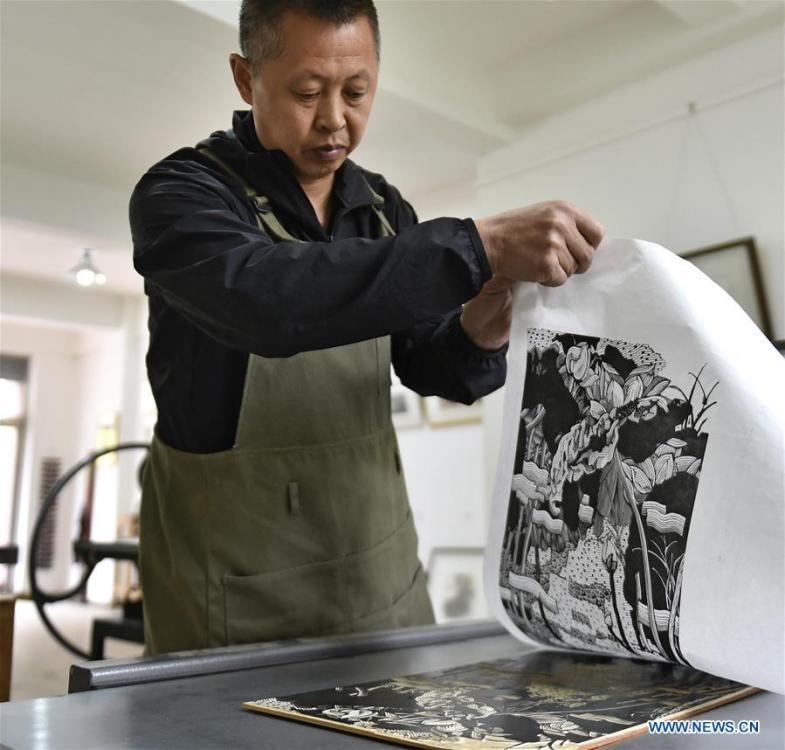 <?php echo strip_tags(addslashes(Chen Dongming works on a wood-block painting at his studio in Huanren County of Benxi, northeast China's Liaoning Province, May 27, 2019. Chen Dongming, a 52-year-old wood-block painter from Wafang Village of Huanren County in Benxi, learned the techniques from his grandfather since young. As an inheritor of Huanren wood-block painting, a provincial intangible cultural heritage in Liaoning, Chen has been committed to making a proper integration of traditional Chinese landscape paintings and wood-block New Year paintings to promote the craft in an innovative way. (Xinhua/Yao Jianfeng))) ?>