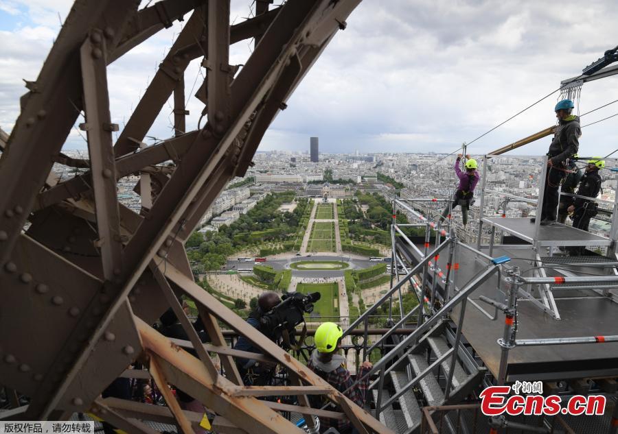 A person rides on a zip-line descending from the second floor of the Eiffel Tower on May 28, 2019 in Paris. The 800 meter crossing takes one minute at a speed of 90km/h. The zip-line will be opened from May 29 to June 2, 2019. (Photo by Eric Feferberg / AFP)