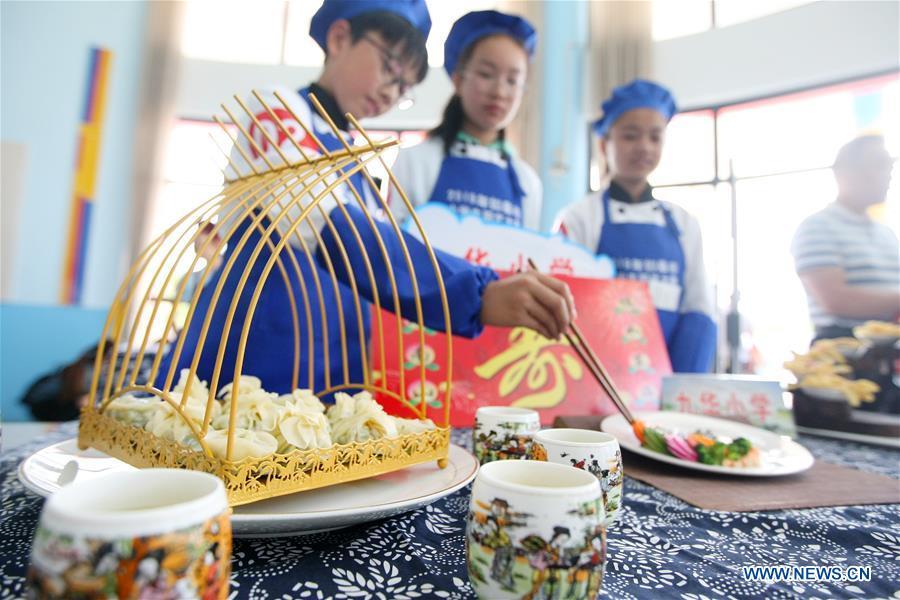 Students show their cooking skills in an event to greet the upcoming International Children\'s Day at a primary school in Rugao, east China\'s Jiangsu Province, May 29, 2019. (Xinhua/Xu Peiqin)