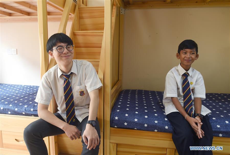 Thuch Salik (R) and a classmate from South Korea pose for photos in their dormitory at a foreign language school in Zhuji, east China\'s Zhejiang Province, May 29, 2019. Thuch Salik became viral overnight when a video clip showing him selling souvenirs in a dozen distinct languages near Angkor Wat was shared online on November 2018. Born in a family with financial difficulties, the 14-year-old Cambodian boy got global attention for his multilingual talent. In May, Salik was offered a place at a foreign language school in Zhuji of east China\'s Zhejiang Province on an education programme funded by a private sponsor in China. Salik said he has high expectations for his education opportunity and life in China. (Xinhua/Han Chuanhao)
