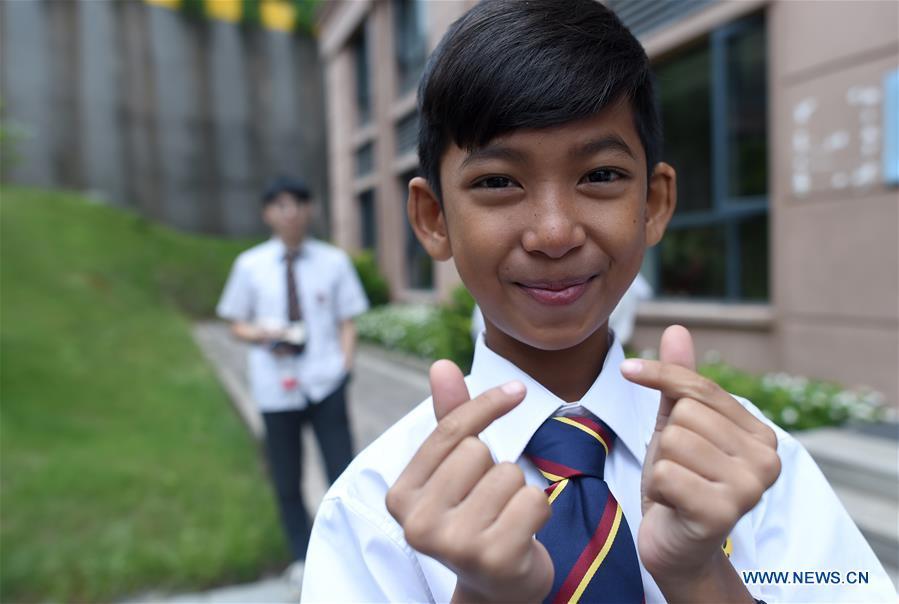 Thuch Salik poses for photos outside his dormitory at a foreign language school in Zhuji, east China\'s Zhejiang Province, May 29, 2019. Thuch Salik became viral overnight when a video clip showing him selling souvenirs in a dozen distinct languages near Angkor Wat was shared online on November 2018. Born in a family with financial difficulties, the 14-year-old Cambodian boy got global attention for his multilingual talent. In May, Salik was offered a place at a foreign language school in Zhuji of east China\'s Zhejiang Province on an education programme funded by a private sponsor in China. Salik said he has high expectations for his education opportunity and life in China. (Xinhua/Han Chuanhao)