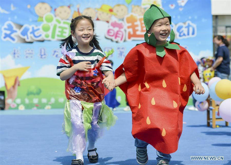 <?php echo strip_tags(addslashes(Children show their handmade clothes during an activity to greet the upcoming International Children's Day at Longshan Kindergarten in Changxing County of Huzhou City, east China's Zhejiang Province, May 29, 2019. (Xinhua/Tan Yunfeng))) ?>