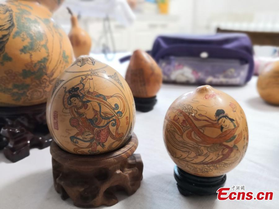Craftswoman Chen Bing shows gourds she carved in Lanzhou City, Gansu Province in June 2019.  The second generation in her family to make artistic creations on gourds, she carved  characters sometimes just one millimeter in size. (Photo: China News Service/Yang Na)