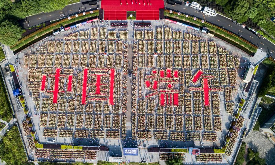 A bird\'s-eye view of the 9,478 people making zongzi, forming four Chinese characters that read \