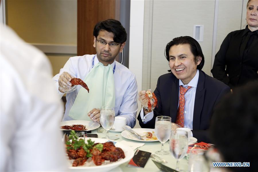 People eat crayfish during the Qianjiang crayfish tasting party at the United Nations headquarters in New York, June 4, 2019. Crayfish, a rarity in Western diet but a favorite of Chinese foodies, on Tuesday made its debut at the UN Delegates Dining Room. Hosted by the city government of Qianjiang, a major producer of crayfish in central China, the tasting party was graced by officials from the UN headquarters, the World Food Programme, the UN Democracy Fund as well as UN diplomats, including representatives from the Dominican and Sri Lankan missions. (Xinhua/Li Muzi)