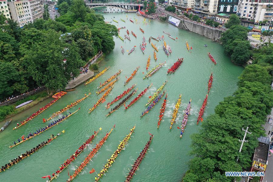 Aerial photo shows people participating in a dragon boat race in Jinjiang River in Tongren City, southwest China\'s Guizhou Province, June 5, 2019. A dragon boat championship was held in Tongren on Wednesday to celebrate the upcoming Dragon Boat Festival, which falls on June 7 this year. (Xinhua/Wu Weidong)
