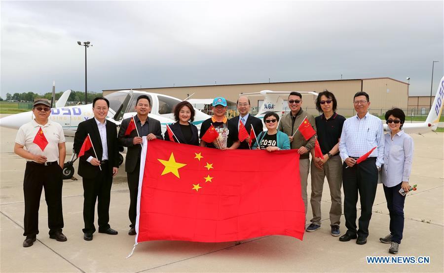 Zhang Bo (5th L) poses for photos in front of his aircraft while receiving a warm welcome from family members and friends at an airport in Chicago, the United States, on June 9, 2019. After flying 68 days and making 50 stops, 57-year-old Bo Zhang completed his second around-the-world flight and landed in Chicago on Sunday morning. On April 2, Zhang kicked off the flight in the same airport in Chicago. In 68 days, he flied through 21 countries in three continents and over three oceans, with total mileage reaching 41,000 kilometers. (Xinhua/Wang Ping)