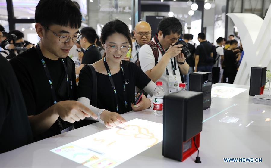 Visitors try a touchable projection product during the 2019 Consumer Electronics Show (CES) Asia in east China\'s Shanghai, June 11, 2019. The 2019 Consumer Electronics Show (CES) Asia kicked off on Tuesday in Shanghai. The three-day exhibition showcased the latest achievements in 5G technology, artificial intelligence, augmented/virtual reality and vehicle technology. (Xinhua/Fang Zhe)