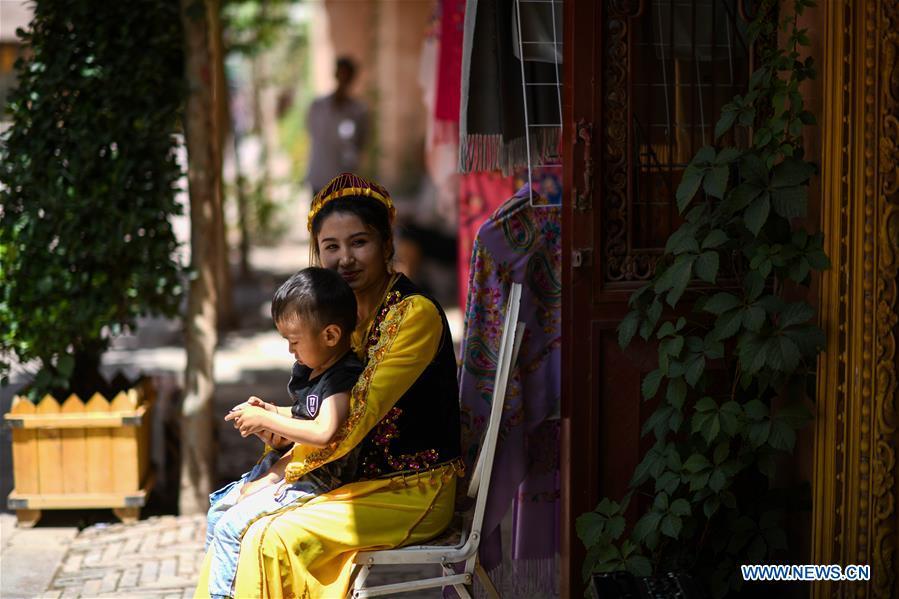 <?php echo strip_tags(addslashes(Local residents sit basking in the sunshine in the ancient city of Kashgar, northwest China's Xinjiang Uygur Autonomous Region, June 12, 2019. The ancient city of Kashgar has been well prepared for the peak tourism season through multiple measures including improving infrastructure and service quality as well as staging acrobatics performances to help tourists better experience the time-honored folk culture here. (Xinhua/Zhao Ge))) ?>