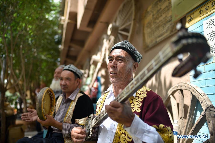 Artists perform for tourists in the ancient city of Kashgar, northwest China\'s Xinjiang Uygur Autonomous Region, June 12, 2019. The ancient city of Kashgar has been well prepared for the peak tourism season through multiple measures including improving infrastructure and service quality as well as staging acrobatics performances to help tourists better experience the time-honored folk culture here. (Xinhua/Zhao Ge)
