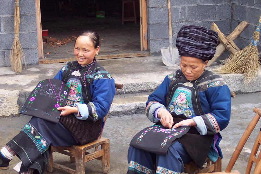 Miao women embroider flowers onto bags.  (Photo provided to chinadaily.com.cn)

Now the Lacy\'s company has 30 employees, with seven working full-time and 15 or 16 women who work part-time at home. Most of the Miao women who embroider for the company have children, and they can travel to the company once a week to take embroidery materials back home so that they can work while taking care of their families, they said. 

The Lacys said that their products have been selling well in the US market because Americans love ethnic handicrafts. They noted that the subprime mortgage crisis in 2008 took a heavy toll on sales. At that time, their customers were largely from South China\'s Guangdong province and Hong Kong.