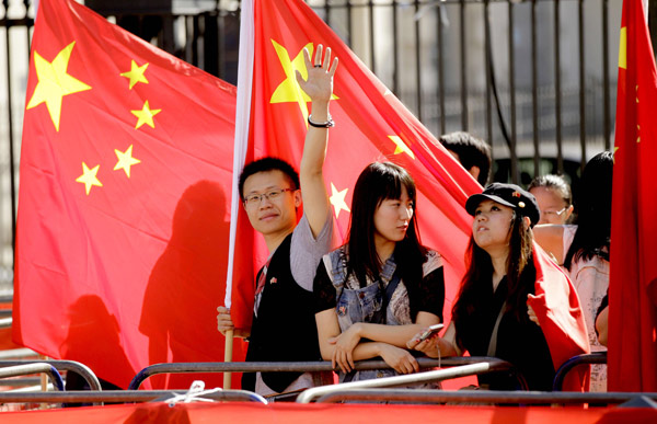 Chinese residents gather outside Downing Street on Monday to welcome Premier Wen Jiabao as he arrived to meet British Prime Minister David Cameron. [Photo/Agencies]