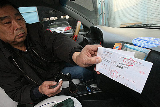 A taxi driver shows receipts for fuel surcharge. Beijing raised its taxi fuel surcharge from 1 yuan to 2 on April 9.