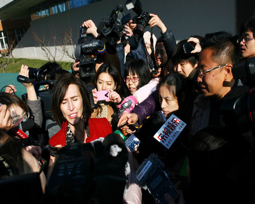 Kim Lee (center), the wife of Li Yang (right), founder of a famous English-language education institution in China, talks to reporters after the couple's divorce hearing at a Beijing court on Thursday. Provided to China Daily