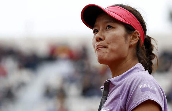 Li Na of China reacts after losing her women's singles match against Kristina Mladenovic of France in the first round of French Open tennis tournament at the Roland Garros stadium in Paris, May 27, 2014. [Photo/Xinhua] 