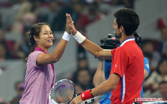 Li Na (L) of china claps hands with Novak Djokovic of Serbia after their charity match before the upcoming 2013 China Open in Beijing, china, Sept. 27, 2013. [Photo: Xinhua]