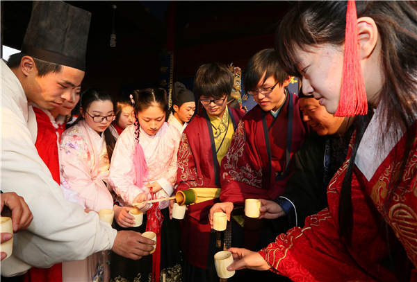 File photo shows people participate in a sacrificial offering to the Kitchen God in Nantong, Jiangsu province, Feb 11, 2015. (Photo by Xu Peiqin/Asianewsphoto)