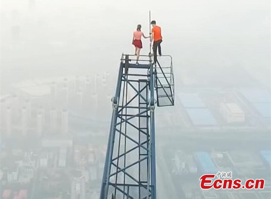 Two Russian climbers, Ivan Kuznetsov, 22, and Angela Nikolau, 23, scale the top of the 640-meter-tall Goldin Finance 117, which is under construction in North Chinas Tianjin Municipality, Aug. 23, 2016. The Russian couple started their climb at 3am and used both cameras and a drone to record the process. The skyscraper is expected to be the tallest building in China after construction is complete. (Photo/CFP)