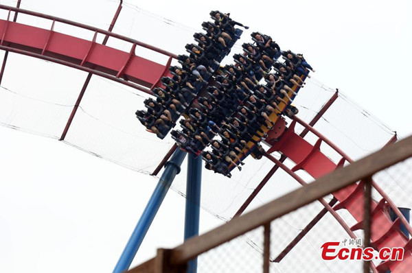 About 100 graduates from 11 universities in Shanghai pose for graduation photos on a roller coaster in Shanghais Happy Valley theme park, June 13, 2016. (Photo: China News Service/Pan Suofei)