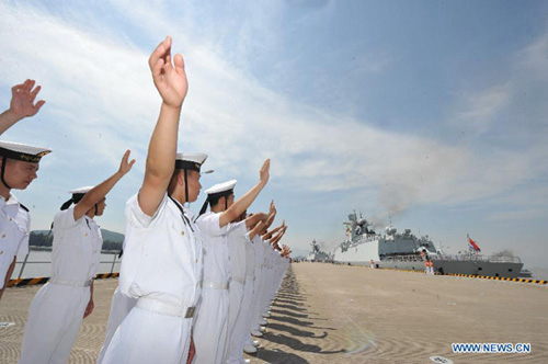 Chinese People's Liberation Army (PLA) Navy soldiers bid farewell to the 12th Chinese naval escort flotilla at a port in Zhoushan, east China's Zhejiang Province, July 3, 2012. [Xinhua]