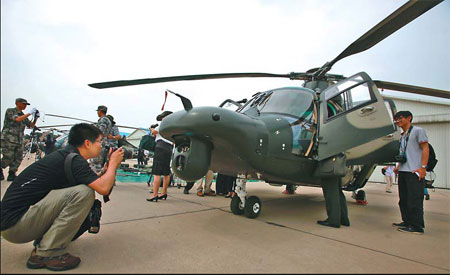 Journalists photograph a Z-9WZ helicopter during a group interview at a military base in Beijing on Tuesday. Wang Jing / China Daily