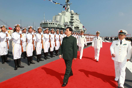 President Hu Jintao, chairman of the Central Millitary Commission, reviews a naval honor guard on the deck of the country's first aircraft carrier in Dalian on Tuesday. (Photo: Xinhua)