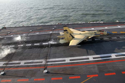 A J-15 fighter jet is slowed by an arresting device as it lands on the Liaoning aircraft carrier in a recent training exercise in Dalian, Liaoning province. [Li Tang / for China Daily]