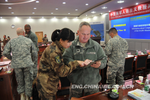 Two officers from the two sides are exchanging views during the interval of the tabletop exercise. (PLA Daily/Yang Liming)