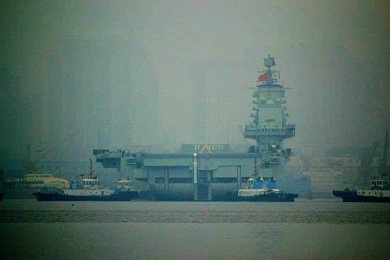 China's first aircraft carrier, the Liaoning, anchored for the first time in a military port in Qingdao, eastern Shandong province on Wednesday morning. (Photo: CCTV) 