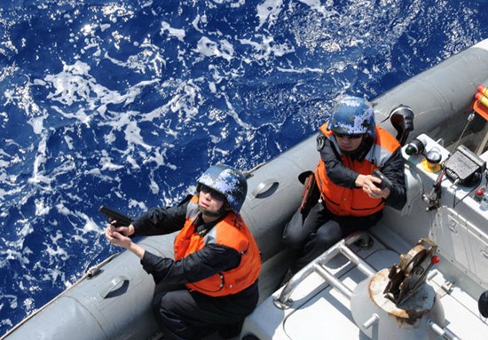 Marines of a brigade of the PLA navy's South China Sea fleet participate in an exercise in which they stopped, boarded and inspected a merchant ship suspected of violating the law, and detained the suspects involved on Thursday. The two marines were on a boat that was sent near the ship. Bai Ruixue / Xinhua
