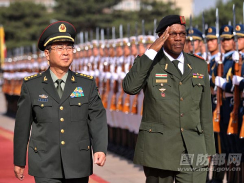 Gen. Fang Fenghui, member of the Central Military Commission (CMC) of the Peoples Republic of China (PRC) and chief of general staff of the Chinese Peoples Liberation Army (PLA), accompanies Colonel Hedwig Gilaard, the visiting commander of the Suriname National Defense Forces, to review the guard of honor of the three services of the PLA on the afternoon of May 30, 2013 in Beijing. (Photo by Li Xiaowei)