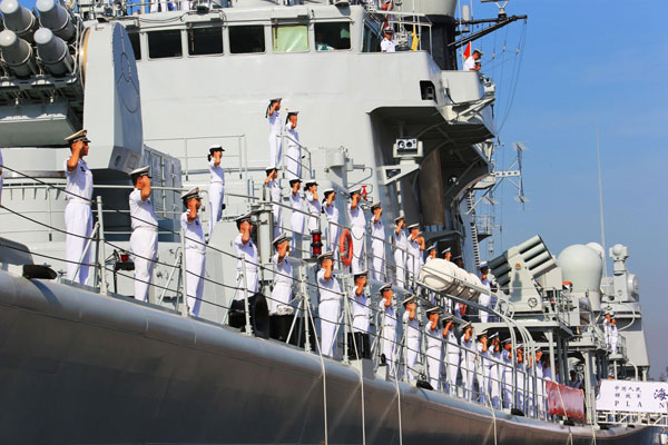 Soldiers of the North China Sea Fleet, one of three fleets of the People's Liberation Army Navy, salute on the missile destroyer Qingdao before departure, in Qingdao, East China's Shandong province, Aug 20, 2013. The ship, carrying nearly 700 soldiers and a helicopter, will visit the United States, New Zealand and Australia, along with escort shipLinyiand depot ship Hongzehu. The fleet will participate in two maritime drills in the US and Australia. [Photo/Xinhua]