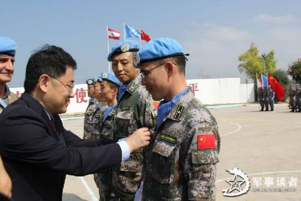 Tan Huangye (R), deputy leader of the 10th Chinese peacekeeping medical detachment to Lebanon, is awarded the United Nations Medal of Peace by Jiang Jiang (L), Chinese ambassador to Lebanon. Recently, 60 peacekeeping officers and men of the 10th Chinese peacekeeping medical detachment to Lebanon were awarded the United Nations Medals of Peace. (Chinamil.com.cn/ Yang Shengchao and Wang Qiang)