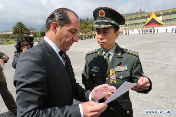 Leader of the Seventh Chinese medical aid team in Ecuador Zhang Guolong (R) receives the The Star of the Armed Forces medal from Ecuador's acting defense minister Carlos Larrea in Quito, Ecuador, Oct. 31, 2013. Ecuador's military Thursday conferred its highest honor on four Chinese medical aid workers, Zhang Guolong, Ma Baojia, Gao Changming and Li Chunpeng, recognizing their great contribution. (Xinhua/Hao Yunfu)