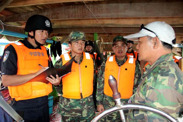 Chinese and Laotian border police check a Laotian merchant ship. 