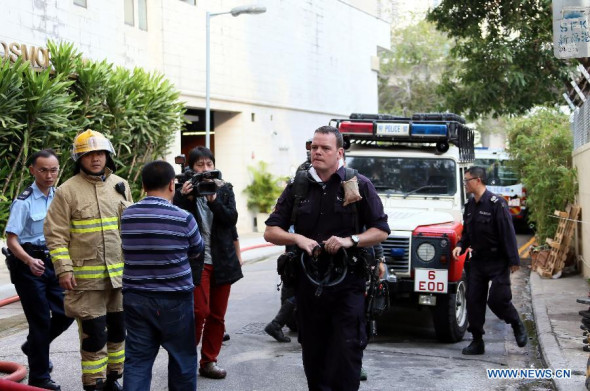 A bomb disposal expert (2nd R) arrives at the venue where a suspected World War II bomb was found by construction workers who were digging underground structure for a hotel on Queen's Road East in Hong Kong island, south China's Hong Kong, Feb 6, 2014. (Xinhua Photo) 